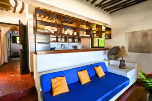 a living room with a blue couch and a kitchen at Kusini Beach Cottages in Diani Beach
