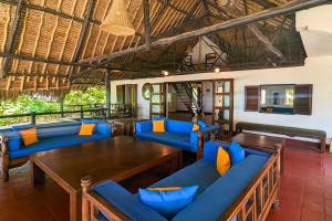 a resort with blue couches and tables in a room at Kusini Beach Cottages in Diani Beach