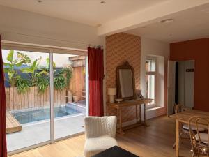 a living room with a view of a swimming pool at La maison cocooning in Narbonne