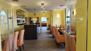 a restaurant with yellow walls and tables and chairs at Asia wok gasthof in Ybbs an der Donau