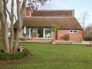 a brick house with a large window and a yard at Three Ways in Diss