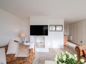 a living room with a couch and a flat screen tv at Three Ways in Diss