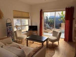 a living room with a couch and chairs and a table at La maison cocooning in Narbonne