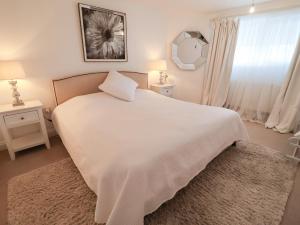 a bedroom with a large white bed and a mirror at Three Ways in Diss