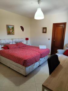 a bedroom with a large bed with a red comforter at Casa Flamenca en El Ventorrillo - Piscina, Tumbonas, Terraza y Aparcamiento in Cúllar-Vega