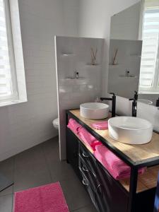 a bathroom with two sinks on top of a counter at La maison cocooning in Narbonne +10 photos
