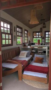 two beds in a room with a table and windows at Vila do Sussurro - Casinha Céu in Triunfo