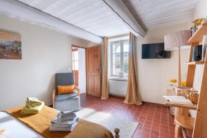 a room with a bed and a chair and a window at Montjoia in L'Isle-sur-la-Sorgue