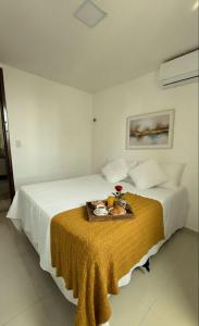 a hotel room with a bed with a tray of food on it at 2 quartos a 300m do mar do bessa in João Pessoa