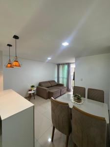 a kitchen and living room with a table and a couch at 2 quartos a 300m do mar do bessa in João Pessoa