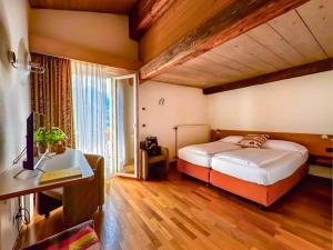a bedroom with a bed and a large window at Hotel Los Andes in Castello di Fiemme +44 photos