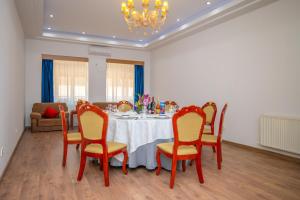 a dining room with a table with chairs and a chandelier at Fude Hotel T bilis第比利斯富德酒店 in Tbilisi City