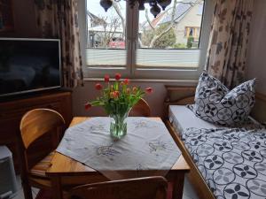 a vase of flowers on a table in a room at Bungalow Poggendorf in Eldena