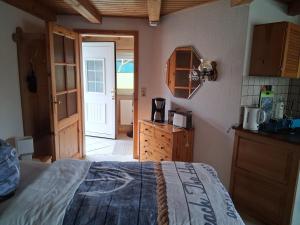 a bedroom with a bed and a door to a kitchen at Bungalow Poggendorf in Eldena