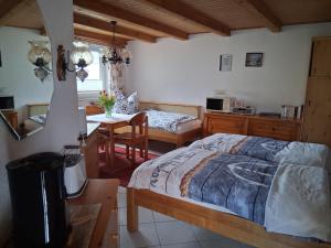 a bedroom with a bed and a kitchen and a table at Bungalow Poggendorf in Eldena