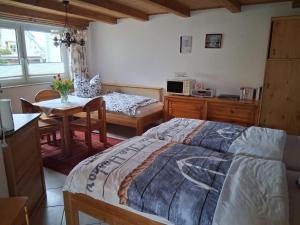 a bedroom with a bed and a table and a desk at Bungalow Poggendorf in Eldena +12 photos