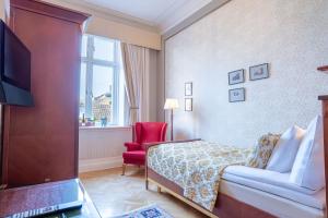 a hotel room with a bed and a red chair at Grand Hotel Lund in Lund