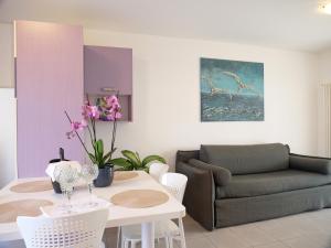 a living room with a table and a couch at Mareblu Apartments Grado in Grado
