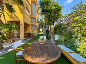 a wooden table and chairs in a yard at Villa Rocamar by Hello Homes Sitges in Sitges