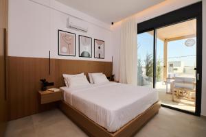 a bedroom with a large bed and a balcony at POLYTELIA - Luxury Living in Elaía +53 photos