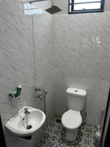 a bathroom with a white toilet and a sink at HomeStay Rafiza in Jertih +9 photos