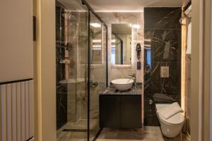 a bathroom with a shower and a sink and a toilet at Karaköy Prive Suites in Istanbul