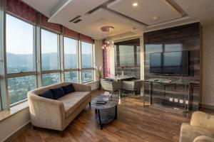 a living room with a couch and a tv at Walk-Inn Centaurus Hotel Apartments Islamabad in Islamabad