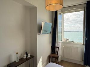 a bedroom with a window with a view of the ocean at Hôtel La Porte Saint Pierre-Logis Hôtel Intra Muros RÉNOVÉ en 2026 in Saint Malo