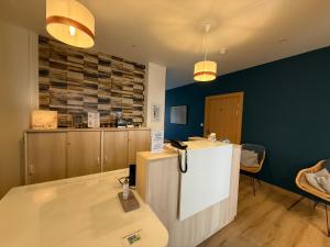 a kitchen with a counter and a refrigerator in a room at Hôtel La Porte Saint Pierre-Logis Hôtel Intra Muros RÉNOVÉ en 2026 in Saint Malo +160 photos