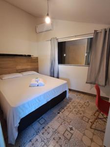 a bedroom with a bed and a chair and a window at Kitnet Apart-Hotel 4 in Sete Lagoas