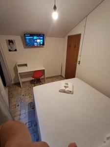 a room with a white table and a red chair at Kitnet Apart-Hotel 4 in Sete Lagoas
