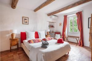 a bedroom with a bed with red and white pillows at Montjoia in L'Isle-sur-la-Sorgue +99 photos
