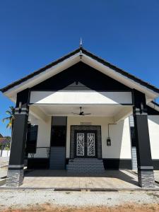 a white building with a door with a porch at HomeStay Rafiza in Jertih