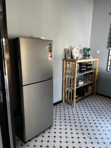 a kitchen with a stainless steel refrigerator in a room at HomeStay Rafiza in Jertih