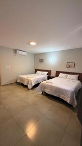 two beds in a large room with at Hotel Recife in Ciudad del Este