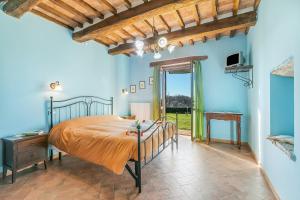 a bedroom with a bed in a room with blue walls at Le Sorgenti in Pitigliano +53 photos