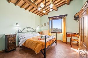 a bedroom with a bed and a desk and a window at Le Sorgenti in Pitigliano