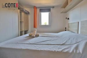 a teddy bear sitting on top of a bed at Bleu Paradou - Bungalow - 6 couchages in Carry-le-Rouet