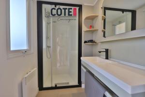 a glass shower in a bathroom with a white sink at Bleu Paradou - Bungalow - 6 couchages in Carry-le-Rouet