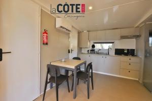 a kitchen and dining room with a table and chairs at Bleu Paradou - Bungalow - 6 couchages in Carry-le-Rouet