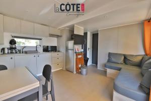 a kitchen and living room with a couch and a table at Bleu Paradou - Bungalow - 6 couchages in Carry-le-Rouet +11 photos