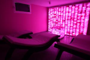 a room with pink lighting and a bed and a chair at Maritan Hotel & Spa in Padova +77 photos