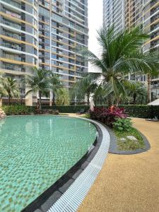 a swimming pool with palm trees and tall buildings at Oliver's vacation home - Vinhomes Grand Park in Long Bình