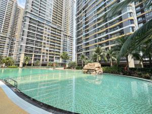 a large swimming pool in front of tall buildings at Oliver's vacation home - Vinhomes Grand Park in Long Bình