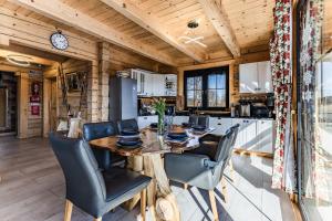 a kitchen and dining room with a wooden table and chairs at Villa Ligęzówka in Chyrowa