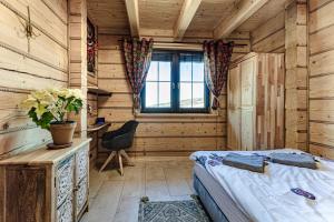 a bedroom with a bed and a desk and a window at Villa Ligęzówka in Chyrowa