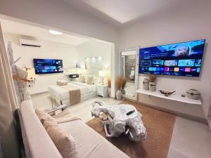 a living room with a couch and a large tv at Studio Crème by The Prime Escape in Arusha