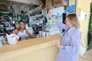 a woman standing at a counter holding up a donut at Antonia's Home - casa per le vacanze con giardino e veranda attrezzati in San Domino