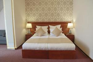 a bedroom with a bed with pillows and two lamps at Passage Hotel Restaurant in Goris