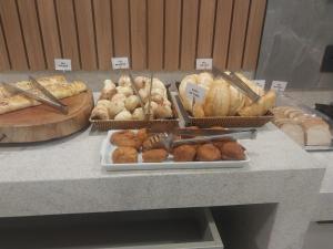 a table with different types of bread and pastries at Presidente Hotel in Passos